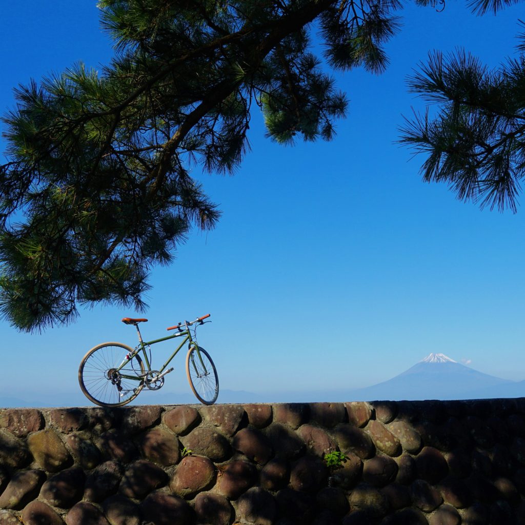 Mount Fuji on a late summer day viewed from Heda Harbour in Shizuoka with a bike from a coastal bike tour in the foreground